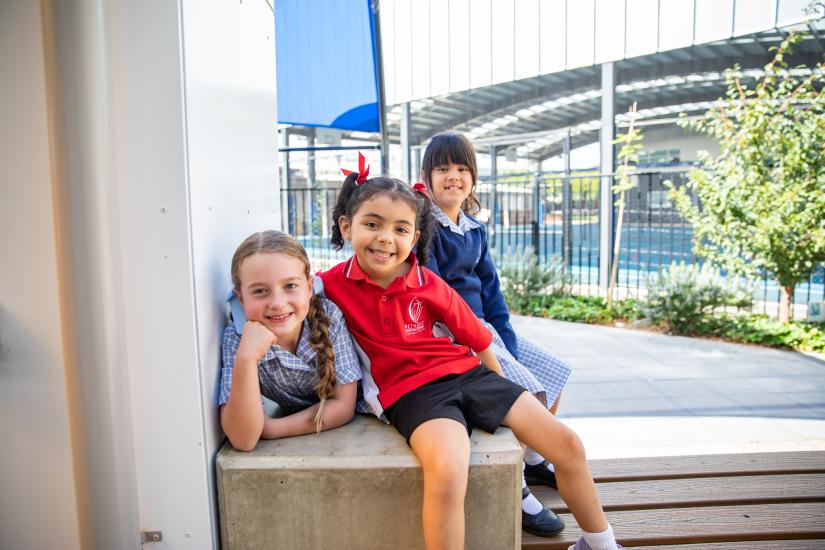 Three young students in the school's playground
